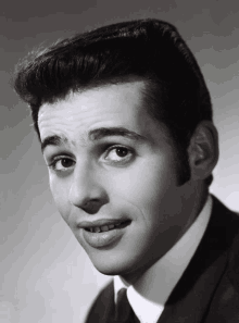 a black and white photo of a young man in a suit