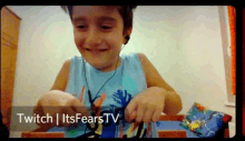 a young boy wearing ear buds is smiling in front of a screen that says twitch itsfearstv