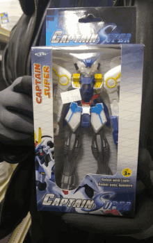 a person is holding a captain super toy robot