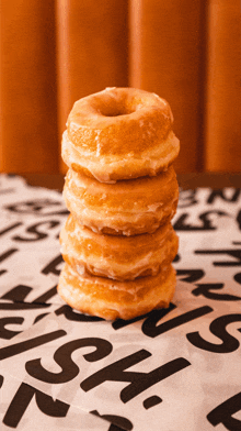 a stack of glazed donuts sits on a piece of paper with the letters n and s on it