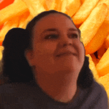 a close up of a woman 's face with french fries in the background