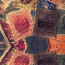 a stack of postage stamps including one that says 15 cents