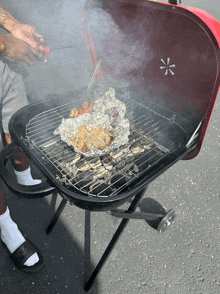 a person cooking food on a grill with the lid open and smoke coming out of it