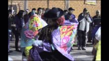 a group of people are dancing in front of a brick wall and a sign that says ' a ' on it