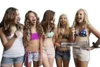 a group of young girls sticking their tongues out while eating ice cream