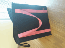 a black tote bag with a pink handle and a n on it