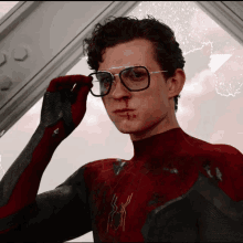 a close up of a man wearing glasses and a spiderman suit