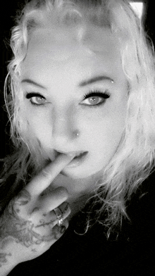 a black and white photo of a woman with a nose ring