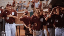 a group of baseball players are standing in a dugout and one of them has the number 15 on his shirt