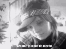 a black and white photo of a girl with the words encore une journee de merde below her