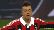 a man wearing a red and black adidas jersey