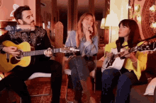 a man playing a guitar and two women singing