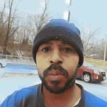 a man with a beard wearing a blue beanie and a blue shirt