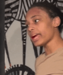 a woman is making a funny face while standing in front of a zebra print wall .