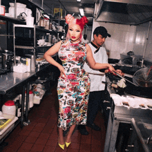 a woman in a floral dress stands in a kitchen with a chef