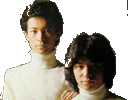 two men are standing next to each other wearing turtlenecks .