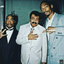 snoop dogg and two other men pose for a picture with the letter a on the bottom right