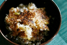 a close up of a bowl of food with rice and vegetables