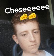 a young boy with cheese on his head and the words cheseeeee behind him