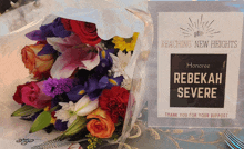 a bouquet of flowers sits on a table next to a thank you for your support sign