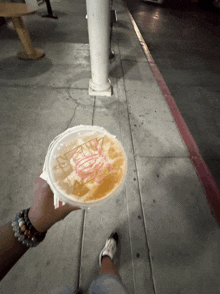 a person holding a cup of iced tea that says ' iced tea ' on the lid