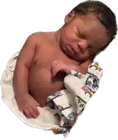 a newborn baby wrapped in a blanket with cars on it