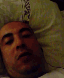 a man laying in bed with his eyes closed and his mouth open