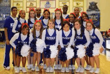 a group of cheerleaders are posing for a picture together on a basketball court .