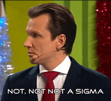 a man in a suit and tie with a microphone on his ear says " not not not a sigma "