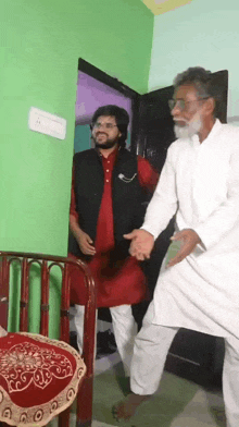 a man in a red shirt and a man in a white shirt are dancing in a room