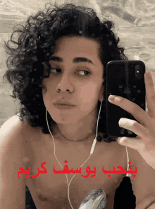 a young man taking a picture of himself with a phone with arabic writing on it