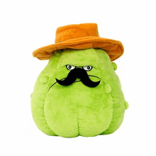 a stuffed green pumpkin with a mustache and hat .