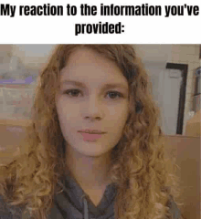 a young girl with curly hair is looking at the camera with a meme .