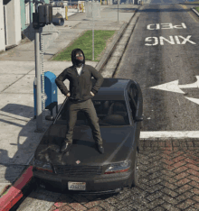 a man in a black hoodie stands on the hood of a black car with a california license plate that says zq82 219