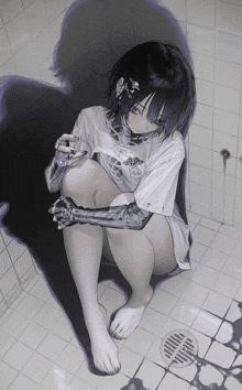 a girl in a white shirt with a cross on it sits in a bathroom next to a drain