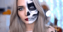 a woman with half of her face painted as a skeleton .