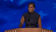 michelle obama is giving a speech at a podium with a blue background