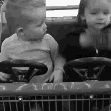 a boy and a girl are sitting in a shopping cart together .