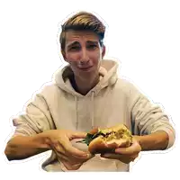 a young man in a white hoodie is holding a hamburger