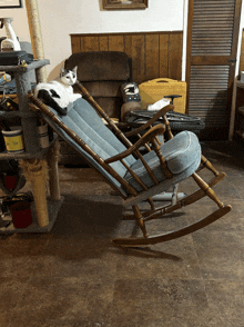 a cat laying on top of a rocking chair in a living room