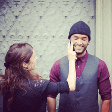 a woman touches a man 's face with her hand