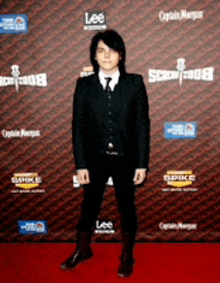 a man in a suit and tie is standing on a red carpet with logos for lee and captain morgan