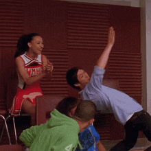 a cheerleader wearing a red uniform with the word cheer on it stands in front of a group of people