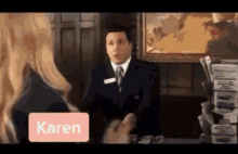 a man in a suit and tie is talking to a woman with the name karen on the screen