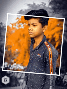 a young boy wearing a champion shirt stands in front of a tree