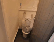 a person laying on a toilet with their feet up