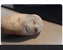 a potato with a hole in it that looks like a face is laying on a table .