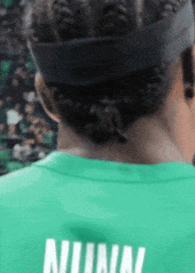 the back of a person wearing a green shirt that says nirvana