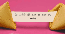 a fortune cookie says la medida del amor es amar sin medida on a pink background