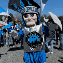 a mascot for blue furia holds a flag